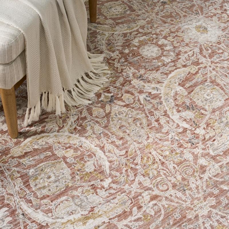 Patterned rug with a chair and blanket on a wooden floor
