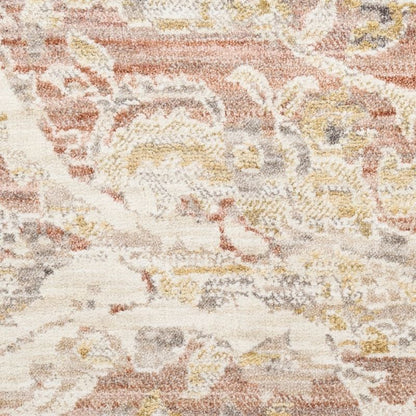 A close-up of a textured area rug featuring an abstract, distressed floral pattern in muted tones of terracotta, beige, cream, and gray.
