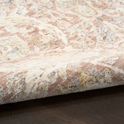 Close-up of a textured area rug with intricate patterns on a wooden floor.