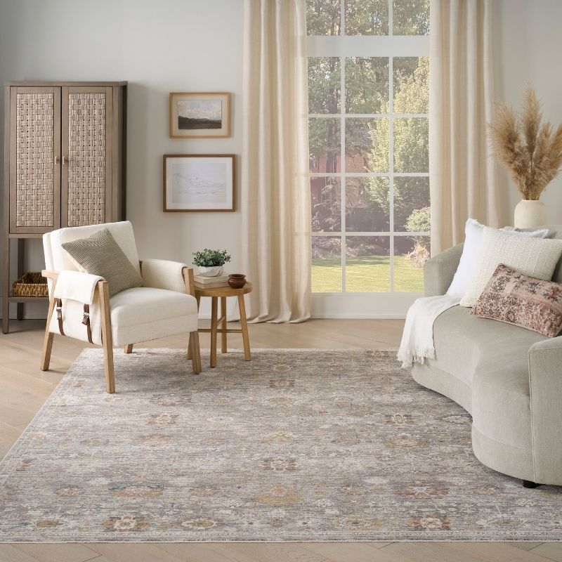 Living room with a gray sofa, armchair, and rug.
