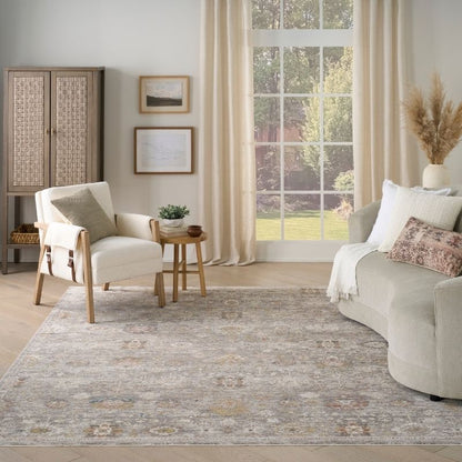 Living room with a gray sofa, armchair, and rug.