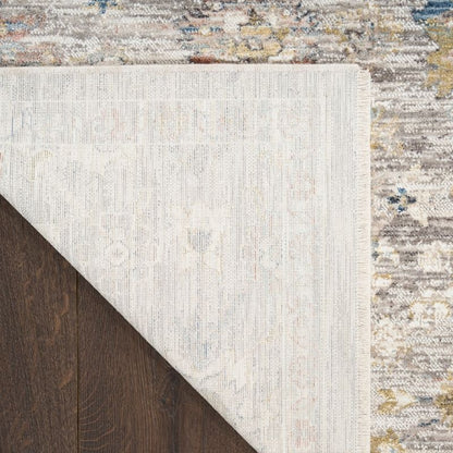 Close-up of a textured rug with a neutral color palette on a wooden floor.