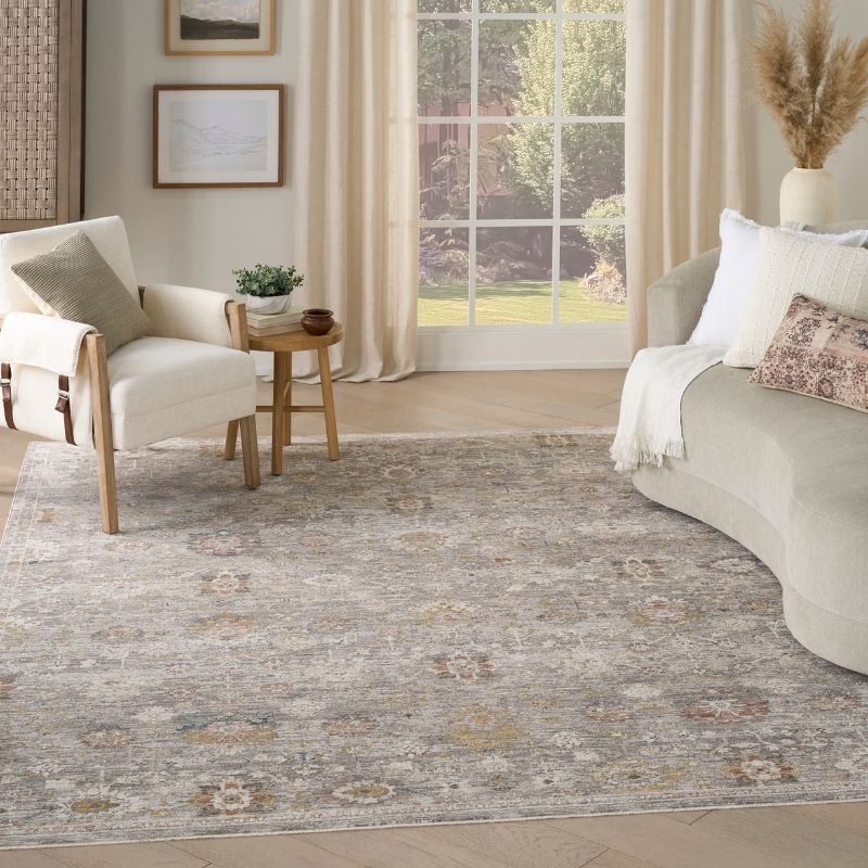 Living room with a patterned rug, sofa, armchair, and side table.