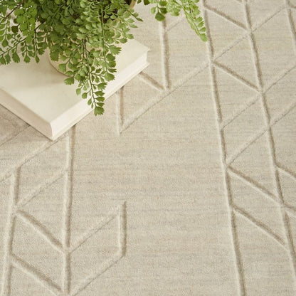 Textured beige carpet with geometric pattern and a book with green leaves on top.