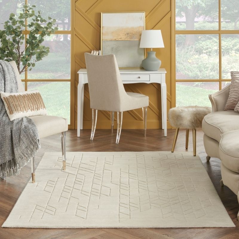 Modern living room with a rug, chairs, and a desk.