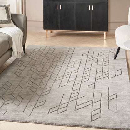 Gray geometric patterned rug in a living room setting with furniture.