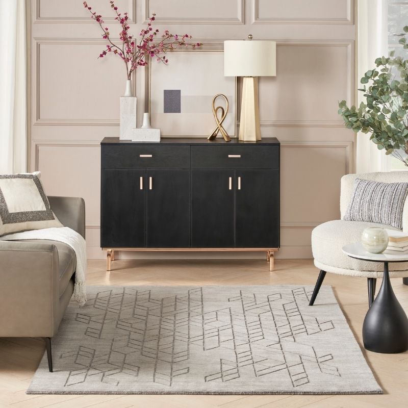 Modern living room with a black sideboard, gray sofa, and decorative elements.