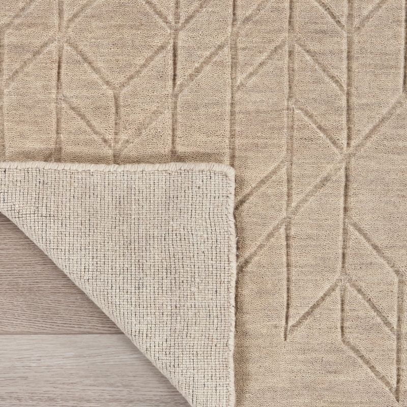 Beige textured rug with geometric pattern on a wooden floor