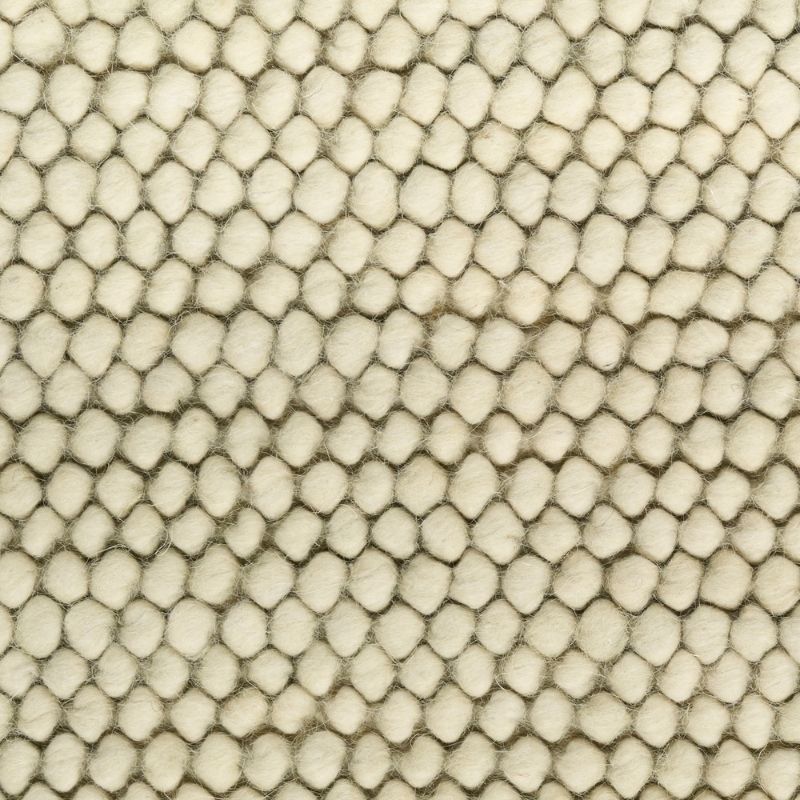 A close-up texture shot of a cream-colored fabric with a raised, hexagonal or honeycomb-like tufted pattern.