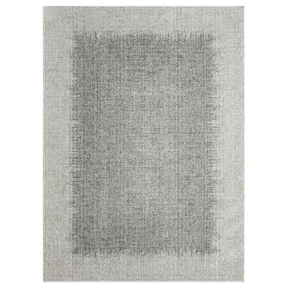 A rectangular area rug with a textured, distressed pattern in shades of gray, featuring a darker gray central panel surrounded by a lighter gray border.