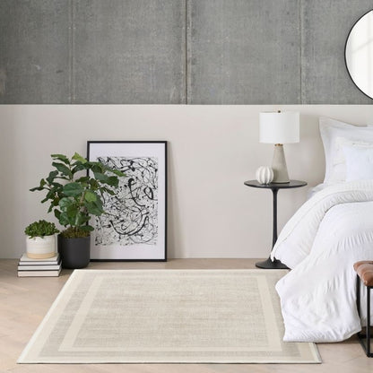Modern bedroom with a bed, side table, lamp, and decorative items.