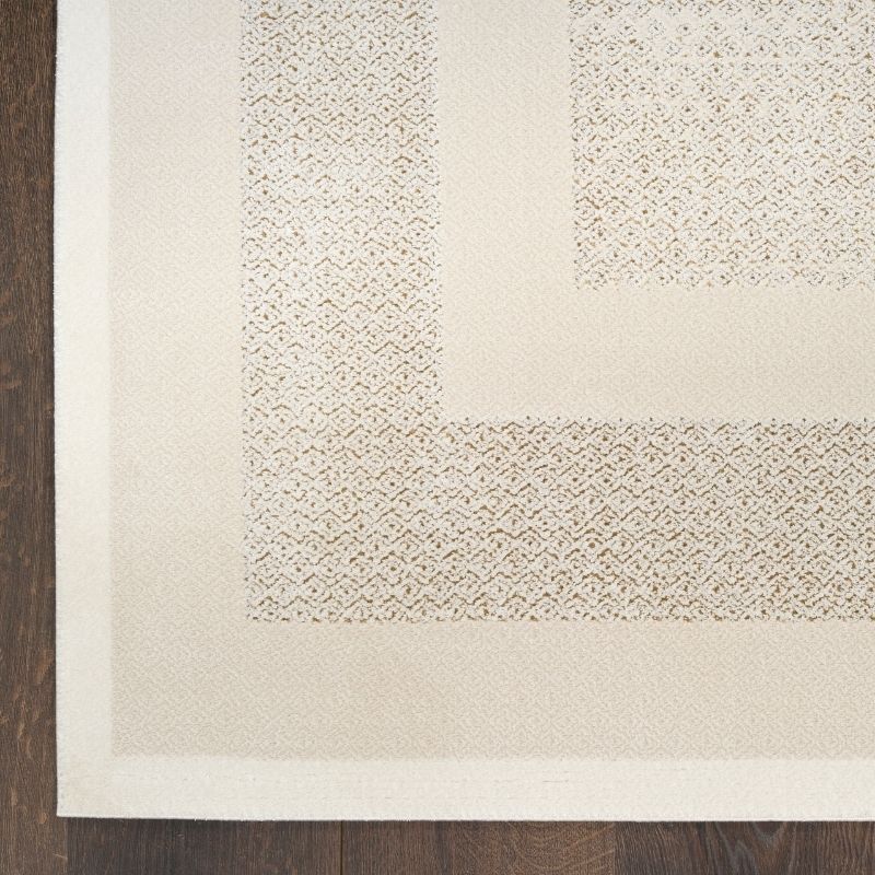 Close-up of a textured beige rug corner on a wooden floor