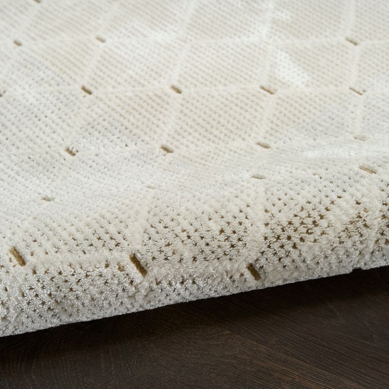 Close-up of a textured white surface with small brown specks on a dark wooden floor.