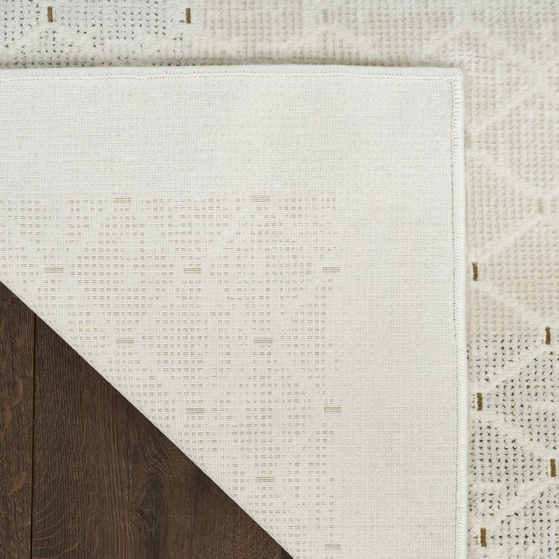 Close-up of a textured white rug with geometric pattern on a wooden floor.