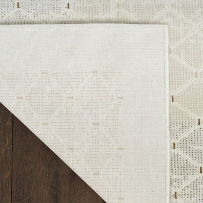 Close-up of a textured white rug with geometric pattern on a wooden floor.