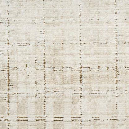 A close-up of a textured fabric or rug surface in warm off-white and beige with a faint distressed grid pattern.