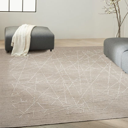 Living room with a geometric patterned rug, gray sofa, and white decor.