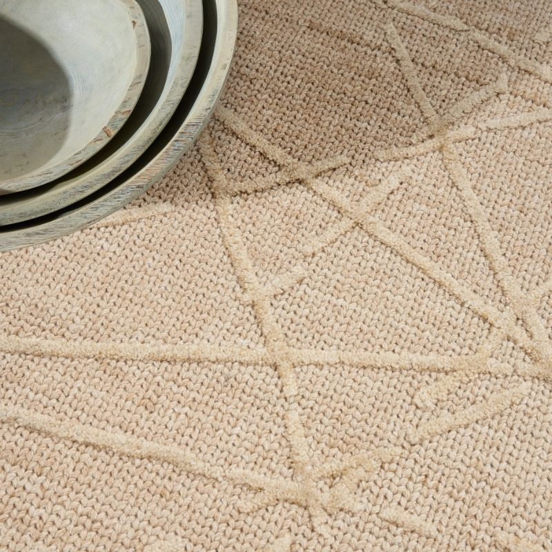 Close-up of a textured beige fabric surface with a woven pattern.
