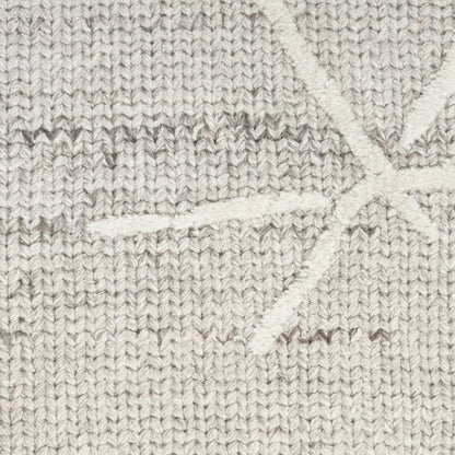 Close-up of a textured knit fabric in a light oatmeal beige color, featuring a subtle white geometric starburst pattern.