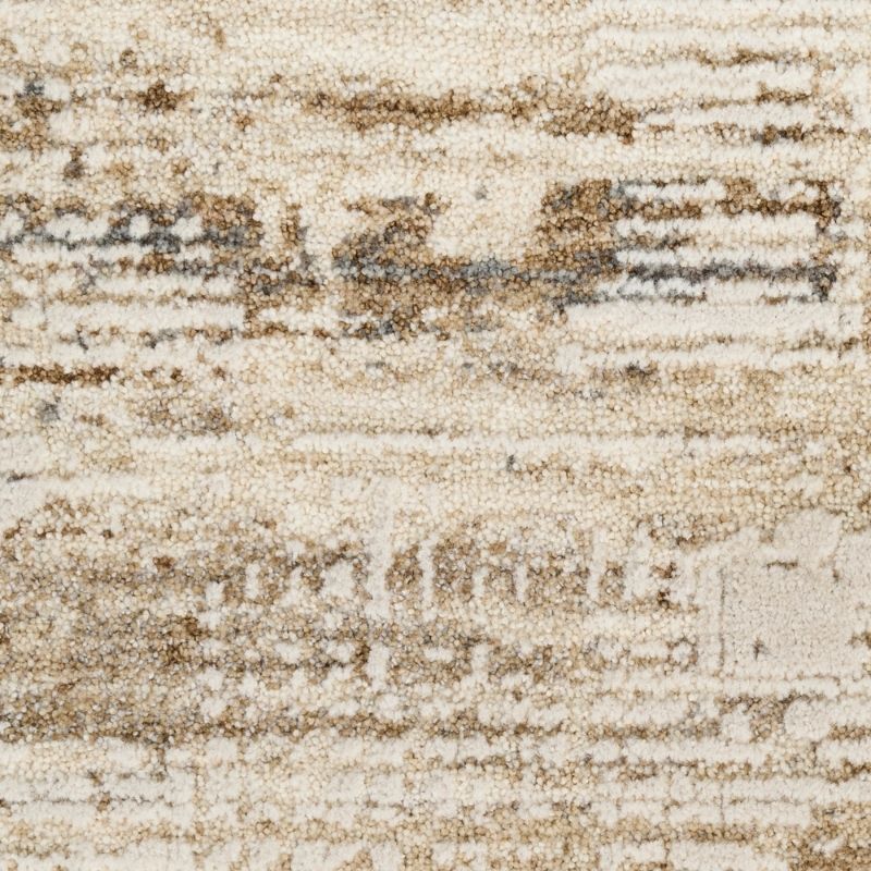 A close-up of a textured area rug with an abstract, distressed pattern in cream, beige, and brown tones.