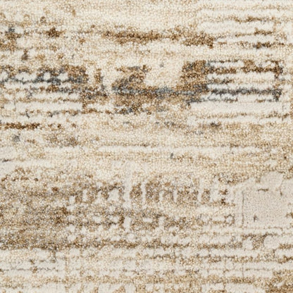 A close-up of a textured area rug with an abstract, distressed pattern in cream, beige, and brown tones.