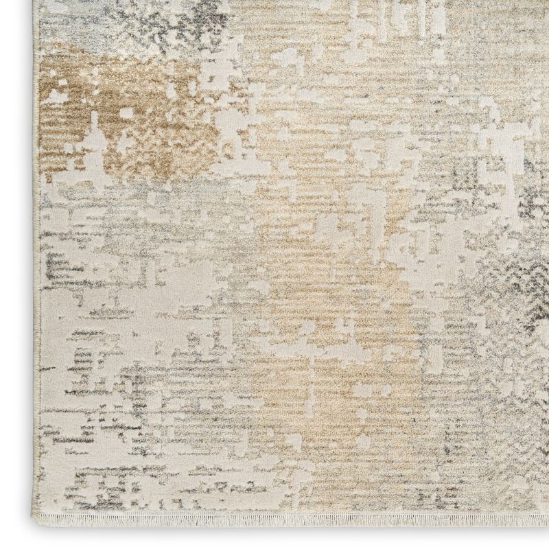A close-up of a textured area rug with an abstract distressed pattern in cream, beige, light gray, and taupe tones.
