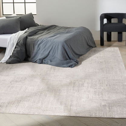 Gray textured rug in a room with a bed and chair.