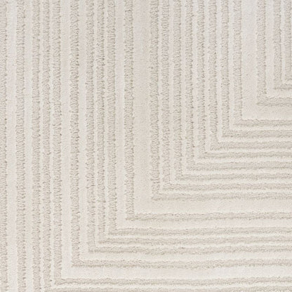 A close-up of a textured area rug featuring a modern chevron or stepped geometric pattern in warm off-white and light beige tones.