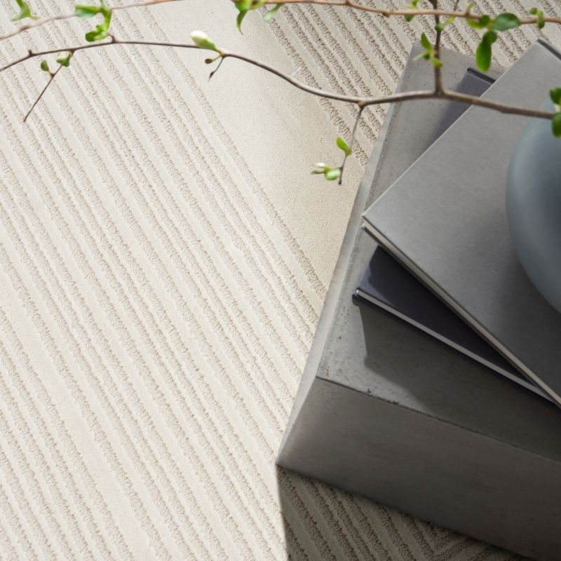 Gray tiles with a textured surface and a branch on a light gray background