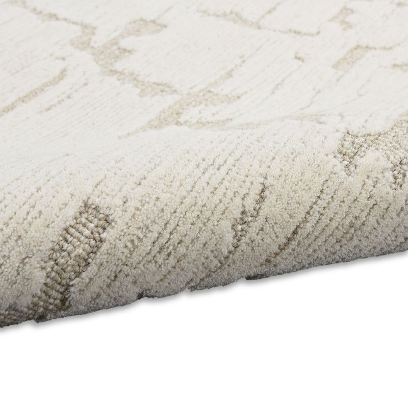Close-up of a textured beige rug with subtle pattern on a white background
