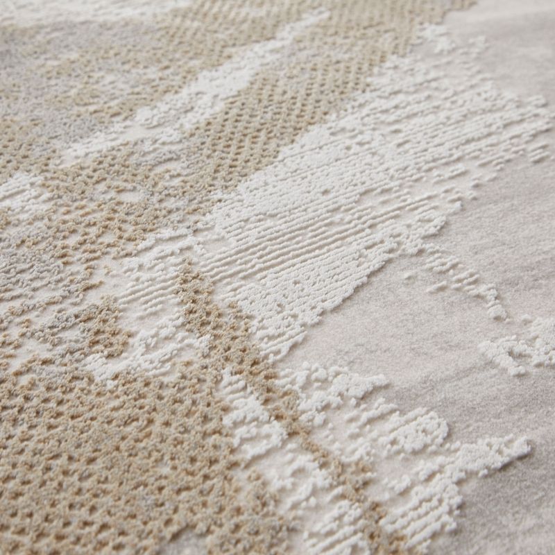 Close-up of a textured area rug with abstract organic patterns in cream, beige, and off-white, showing detailed pile variation.