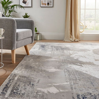 Living room with a gray armchair, coffee table, and patterned rug.