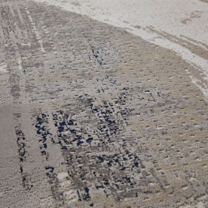 A close-up of a textured surface with a mottled pattern of beige, gray, and dark charcoal patches.