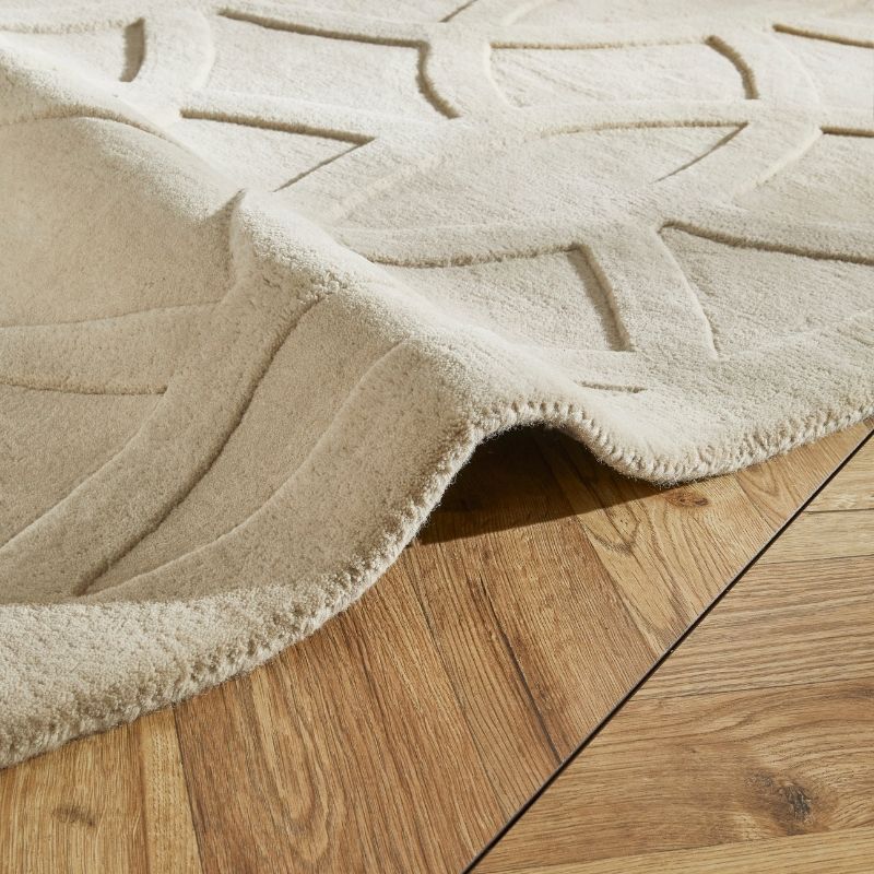 Beige textured rug on a wooden floor
