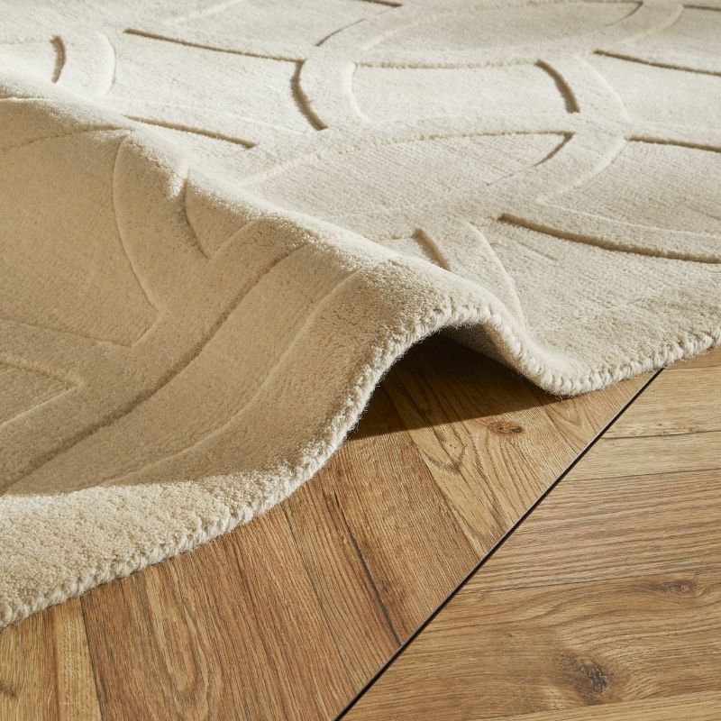 Beige textured rug on a wooden floor