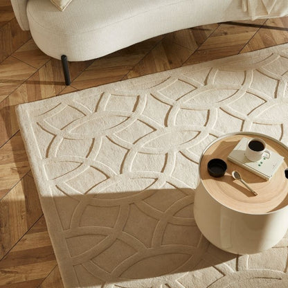 Beige textured rug with geometric pattern on a wooden floor