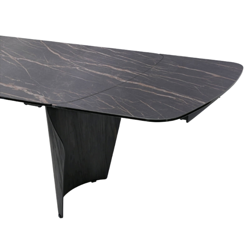 A modern rectangular dining table with a dark black marble top featuring subtle warm beige veining and a sculptural dark wood pedestal base, shown on a solid white background.