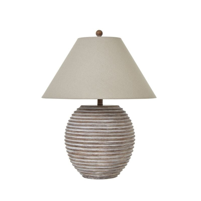 Table lamp with ribbed ceramic base and beige lampshade on a white background