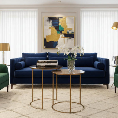 Living room with gray sofa, gold side tables, and white flowers.
