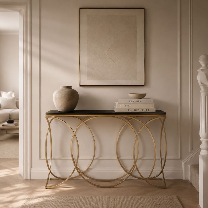 Decorative console table with gold circular legs in a living room setting.